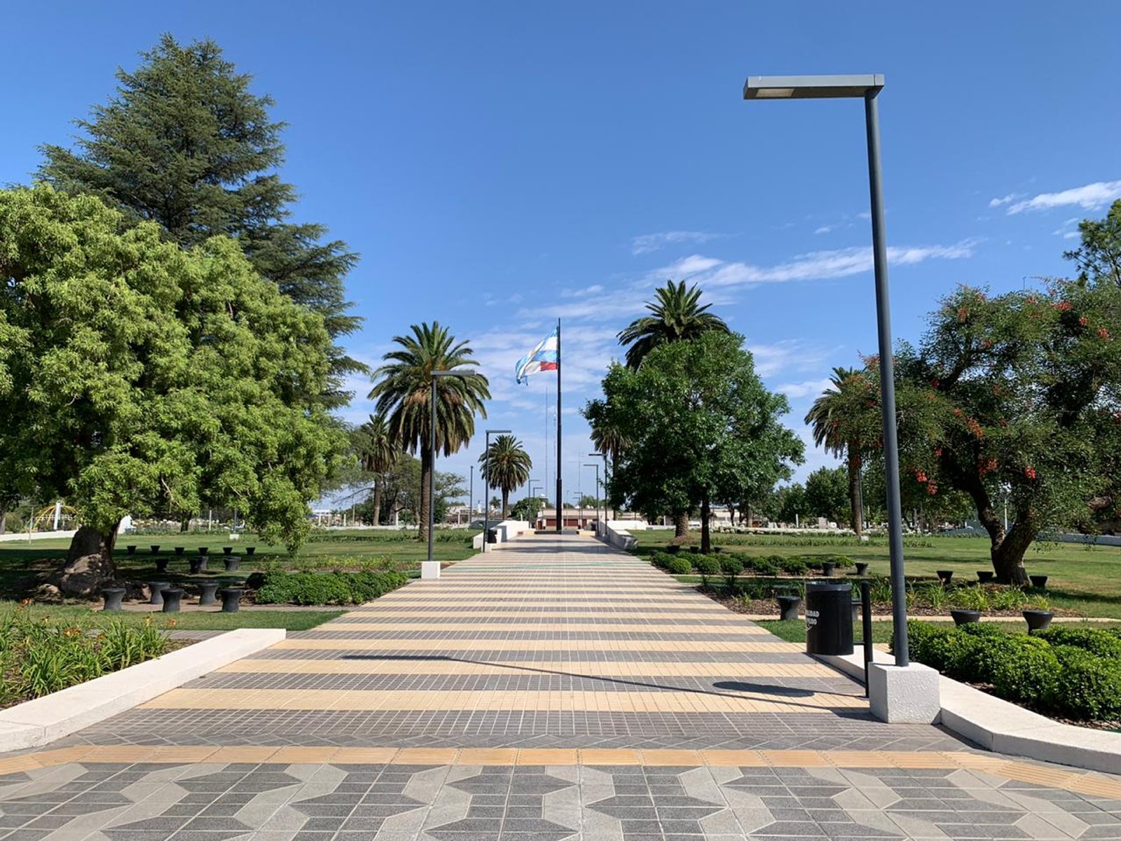 Sendero peatonal con diseño geométrico y farolas modernas — proyecto Plaza General San Martín, por LM arquitecta+paisajista, en RN9 271